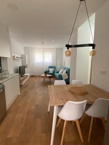 a kitchen and living room with a wooden table and chairs at Apartament centre casaPat in Xàtiva