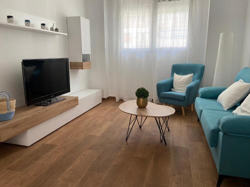 een woonkamer met een tv en een bank en een tafel bij Apartament centre casaPat in Xàtiva