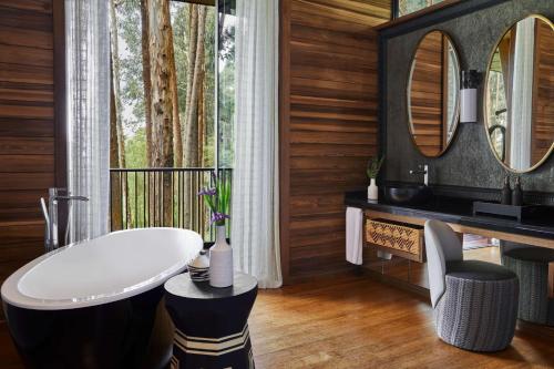 a bathroom with a sink and a mirror at One&Only Gorilla's Nest in Kinigi