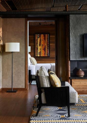 a living room with a couch and a bed at One&Only Gorilla's Nest in Kinigi