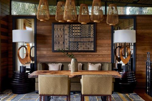 a dining room with a table and chairs and lights at One&Only Gorilla's Nest in Kinigi
