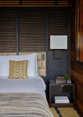 a bedroom with a large bed and a flat screen tv at One&Only Gorilla's Nest in Kinigi