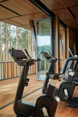 a gym with several treadmills on a wooden deck at One&Only Gorilla's Nest in Kinigi