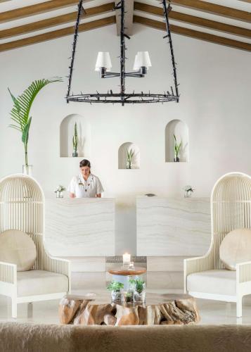 a man standing behind a counter in a room with two chairs at One&Only Palmilla in San José del Cabo