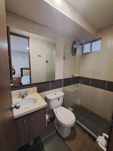a bathroom with a toilet and a sink at Torino Barranquilla- Miramar in Barranquilla