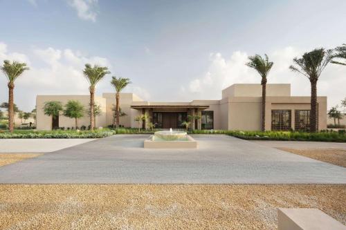 een gebouw met palmbomen ervoor bij Bab Al Shams, A Rare Finds Desert Resort, Dubai in Dubai