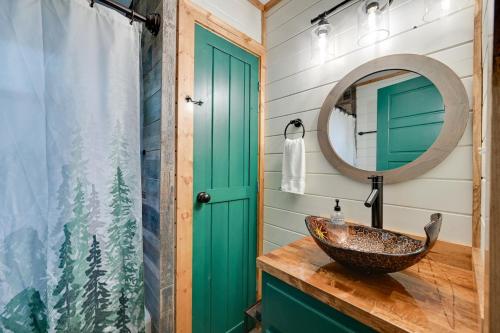 a bathroom with a sink and a mirror at Charming Eagletown Home with Deck and Private Hot Tub! in Eagletown