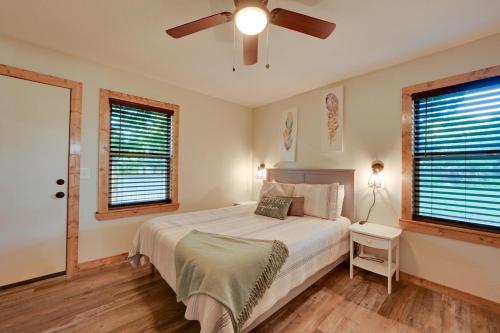a bedroom with a bed and a ceiling fan at Charming Eagletown Home with Deck and Private Hot Tub! in Eagletown