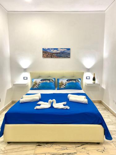 a bedroom with a blue bed with towels on it at Castellano apartment in Naples