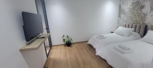 a room with two beds and a flat screen tv at Eden Room SCH in Rabat