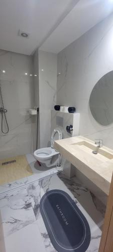 a white bathroom with a toilet and a sink at Eden Room SCH in Rabat