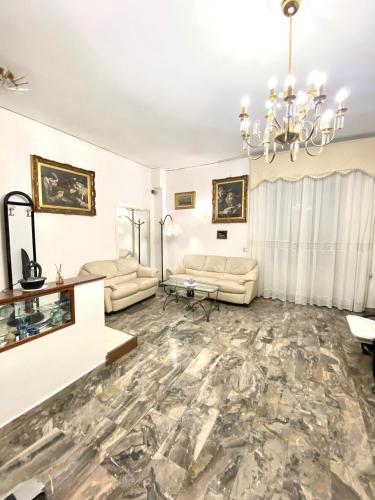 a living room with couches and a chandelier at Castellano apartment in Naples