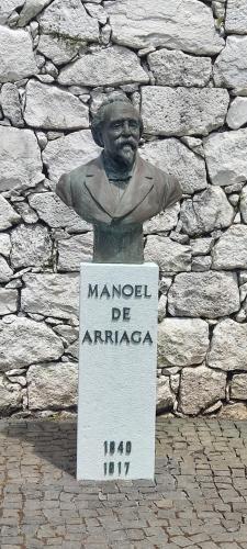 a statue of a man in front of a stone wall at Apartamento Jardins D'Arriaga in Horta