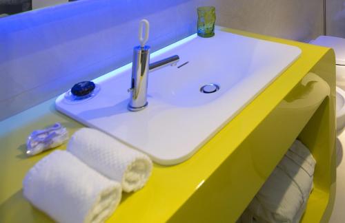 a sink in a bathroom with a yellow counter at The Street Milano Duomo | a Design Boutique Hotel in Milan