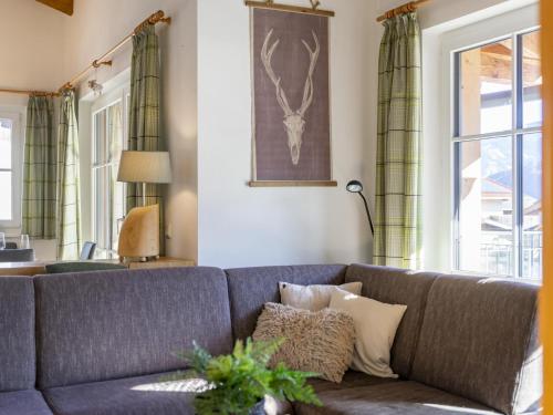 a living room with a gray couch with pillows at Luxury Tauern Suite Walchen Kaprun 4 in Piesendorf