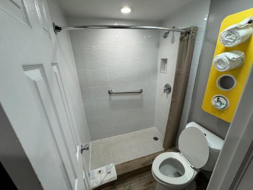a small bathroom with a toilet and a shower at Motel 6 Englewood, FL in Englewood