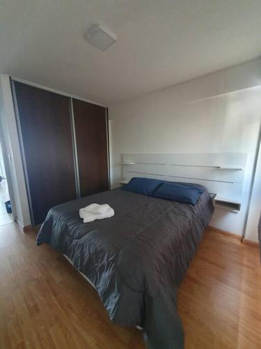 a bedroom with a large bed with blue sheets at Departamento dos ambientes. in Castelar