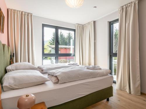 a bedroom with two beds and a large window at Lukasfeld 9 Top Sepp in Hopfgarten im Brixental