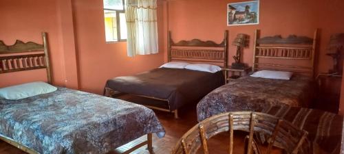 a bedroom with two beds and a chair in it at La Leyenda in Copacabana