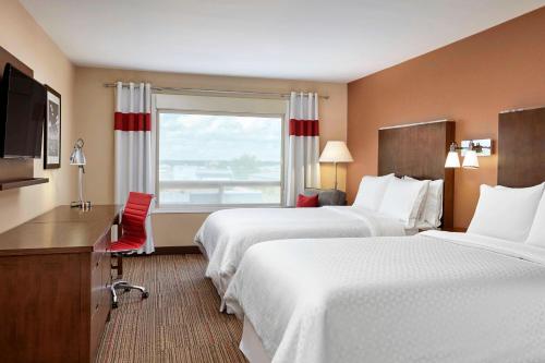 um quarto de hotel com duas camas e uma janela em Four Points by Sheraton Regina em Regina