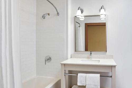 ein weißes Badezimmer mit einem Waschbecken und einem Spiegel in der Unterkunft Four Points by Sheraton Regina in Regina