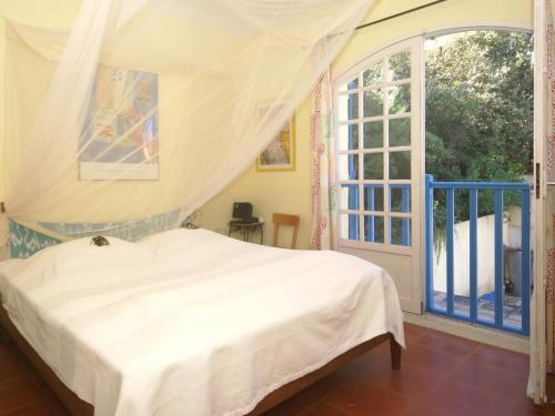 a bedroom with a bed and a large window at Les Iris in Lorgues