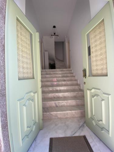 a stairway with two doors and a staircase with stairs at Διαμέρισμα σε ανακαινισμένο αρχοντικό 19ου αιώνα, κέντρο Μύρινας in Mirina