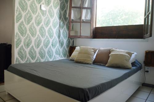 a bed with two pillows on it in a room at departamento en Geriba in Búzios