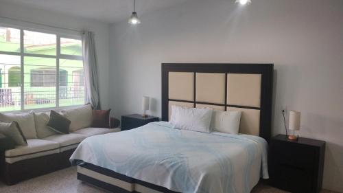 a bedroom with a bed and a couch at PROVENZA HOTEL & SUiTES in Atlixco