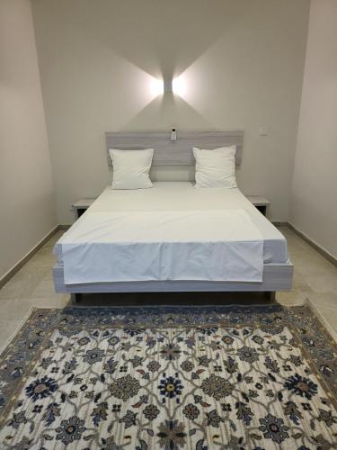a bed with two pillows and a rug in a bedroom at RESIDENCE TERANGA in Kammba