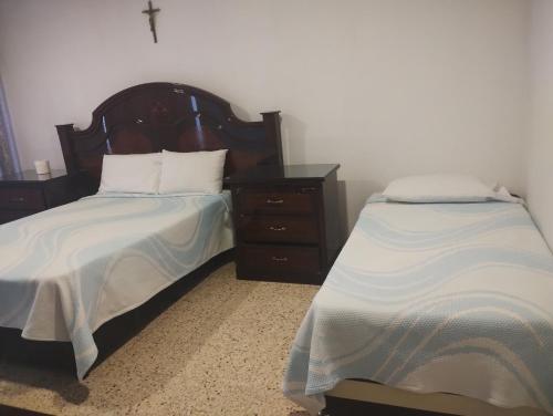 a bedroom with two beds and a dresser at PROVENZA HOTEL & SUiTES in Atlixco