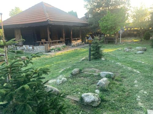 a house with a yard with rocks in front of it at Satul Traditional in Runcu