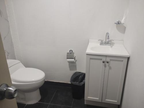 a bathroom with a white toilet and a sink at PROVENZA HOTEL & SUiTES in Atlixco
