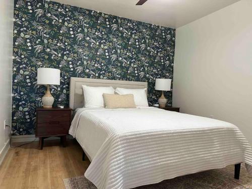 a bedroom with a large bed with a floral wallpaper at Campus Cottage Kng Bed! Walk To Uco And Downtown in Edmond
