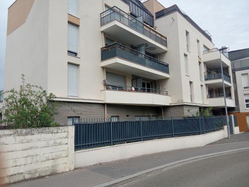 an apartment building with balconies and a fence at Chambre chez l habitants in Villepinte