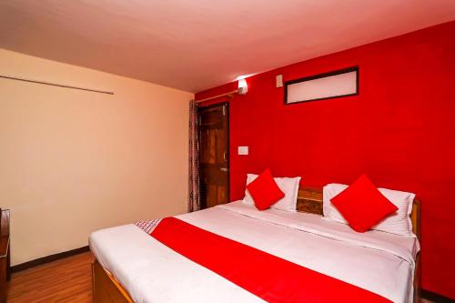 a red room with a bed with a red wall at OYO Flagship View Point Resort in Nainital