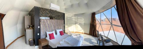 a bedroom with a bed with a large window at Desert heart camp in Wadi Rum