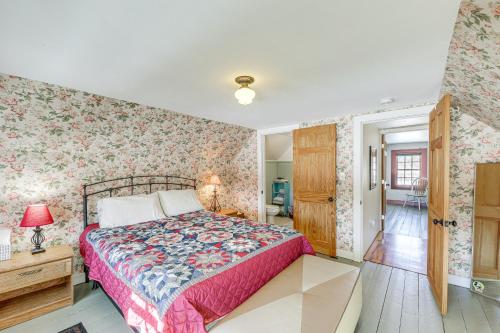 um quarto com uma cama e papel de parede floral em Charming Lovell Farmhouse - 17 Acres with Mtn Views! em Lovell