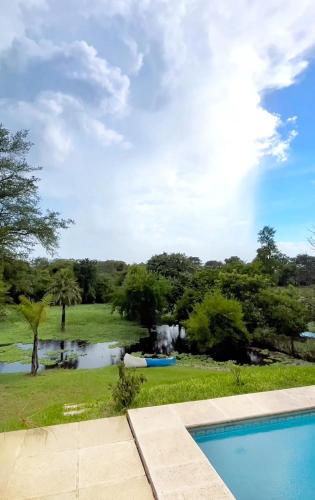 a swimming pool with a view of a river and trees at Portal del Cachilito in Tres Marías