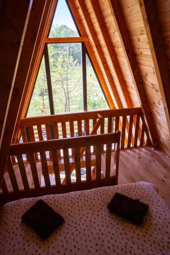 a bed in a room with a large window at Imanje Lotus Garden in Šabac