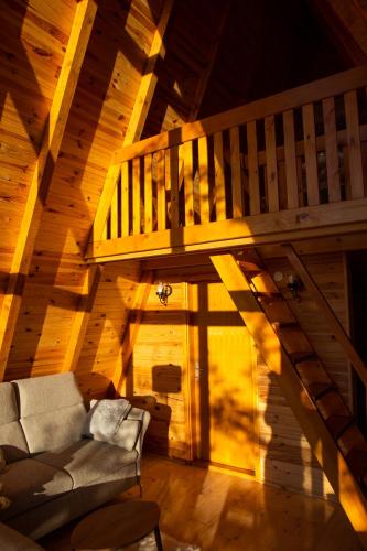a living room with a staircase and a couch at Imanje Lotus Garden in Šabac