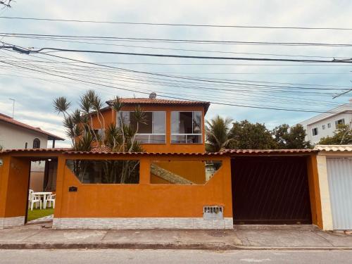 an orange house with a window on top of it at Pousada Costa Mar in Rio das Ostras