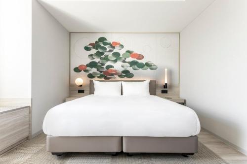 a bedroom with a white bed and a painting at Centara Grand Hotel Osaka in Osaka