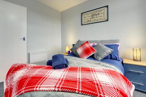 a bedroom with a bed with red and blue pillows at Coventry 2 Bedroom Apartment, Sleeps 4, Parking in Wyken