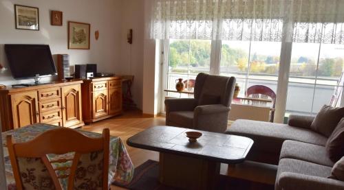 ein Wohnzimmer mit einem Sofa, einem TV und einem Tisch in der Unterkunft Ferienwohnung Rodachtalblick 927 in Bad Rodach