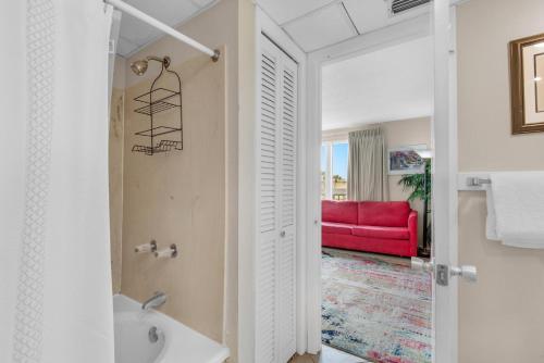 a bathroom with a sink and a red couch at Sandpiper Cove 2017 in Destin