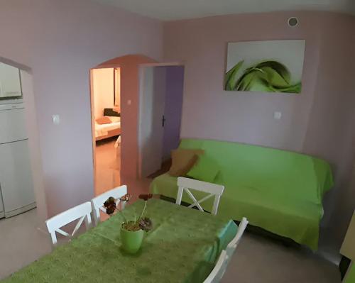 un soggiorno con tavolo verde e divano di Seaside house with a swimming pool Prigradica, Korcula - 22904 a Blato