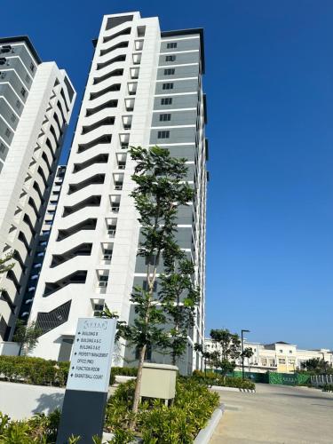 two tall white buildings with a sign in front of them at Family room Casa Mia at SMDC Styles Residence Tower A in Iloilo City