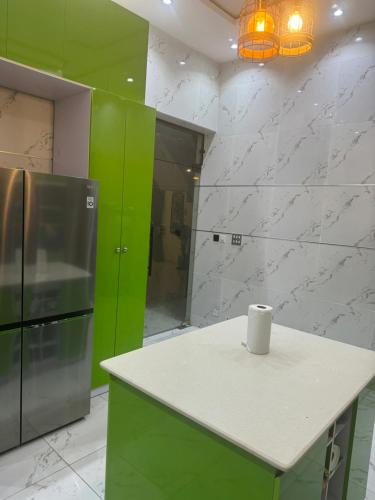 Two bedroom duplex in Chevron Lekki phase 2 في Iranla: مطبخ اخضر وبيض مع كونتر وثلاجة