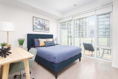 a bedroom with a bed and a table and a desk at 1BD Perfect location Walk to CN Tower! in Toronto